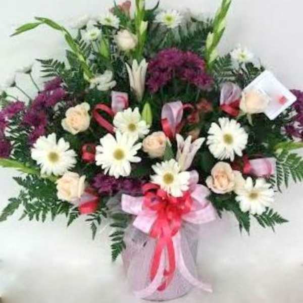 Bouquet of white daisies and pale roses with purple flowers in a vase