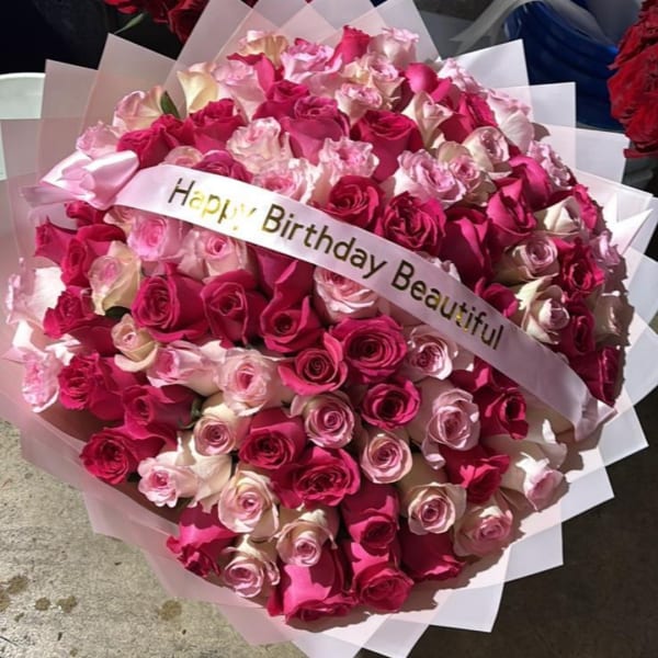 Large bouquet of pink and white roses with a birthday ribbon