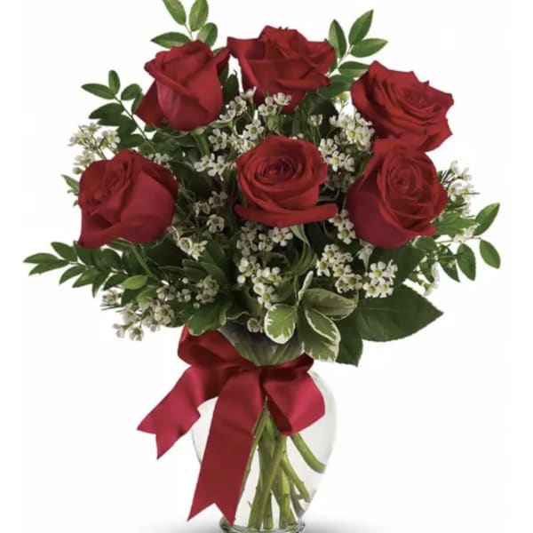 Bouquet of red roses with white filler flowers in a clear glass vase