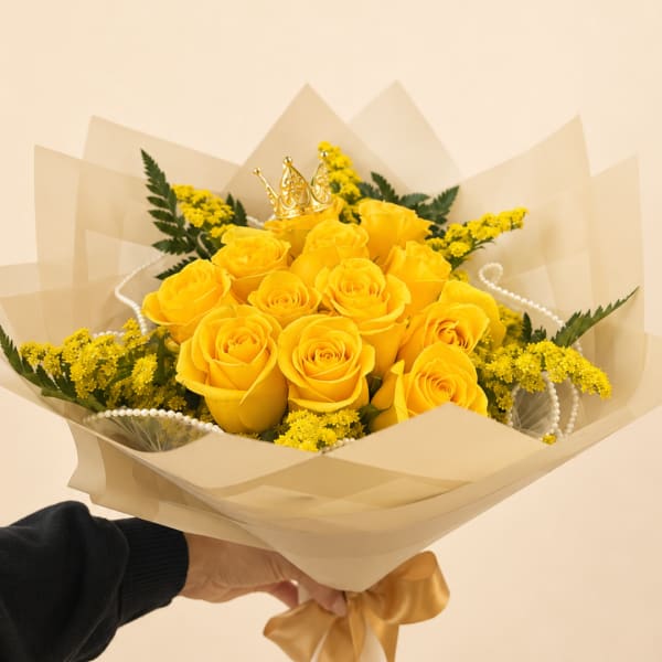 Yellow rose bouquet with a small gold crown topper