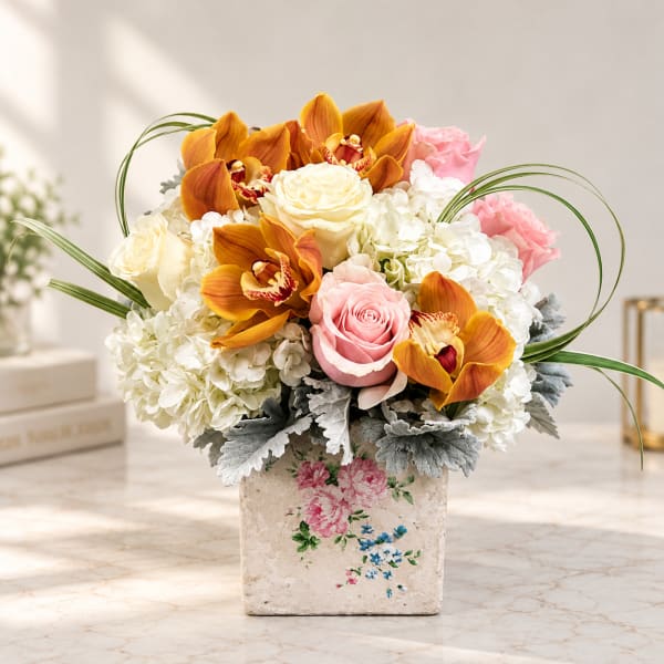 Pink roses and orange orchids in a floral vase arrangement