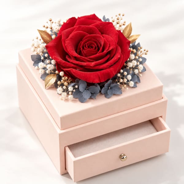 Red rose on a pink gift box with a small floral wreath
