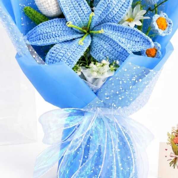 Blue bouquet with crocheted flowers and white daisies wrapped in blue paper