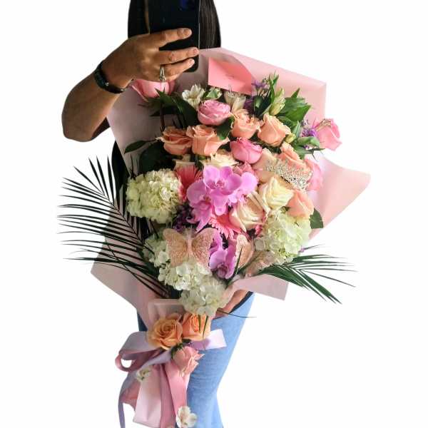 Large pink and peach bouquet with orchids and roses wrapped in pink paper