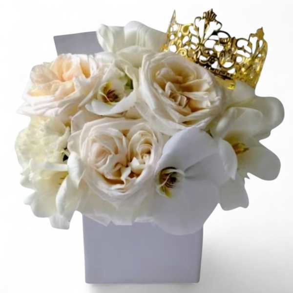 White floral arrangement in a square vase with a gold crown topper
