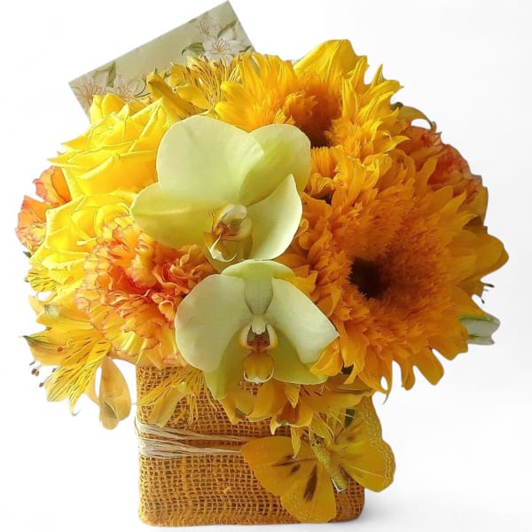 Yellow and orange bouquet with white orchids in a burlap-wrapped container