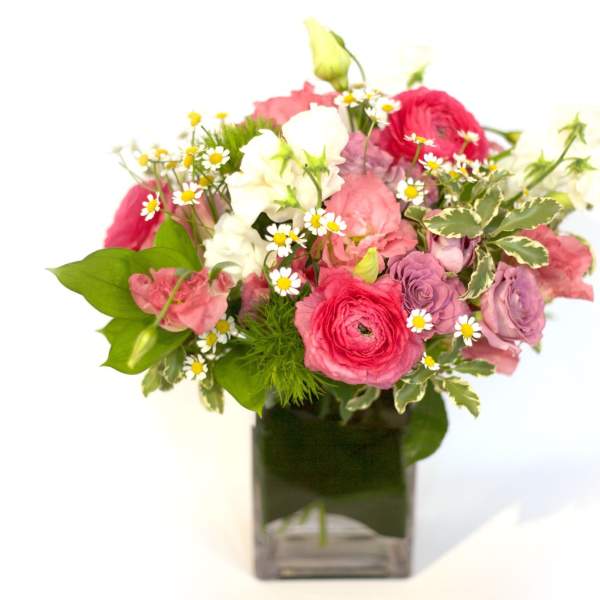Pink and white mixed bouquet in a square glass vase