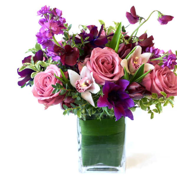 Pink and purple flower arrangement in a clear glass vase