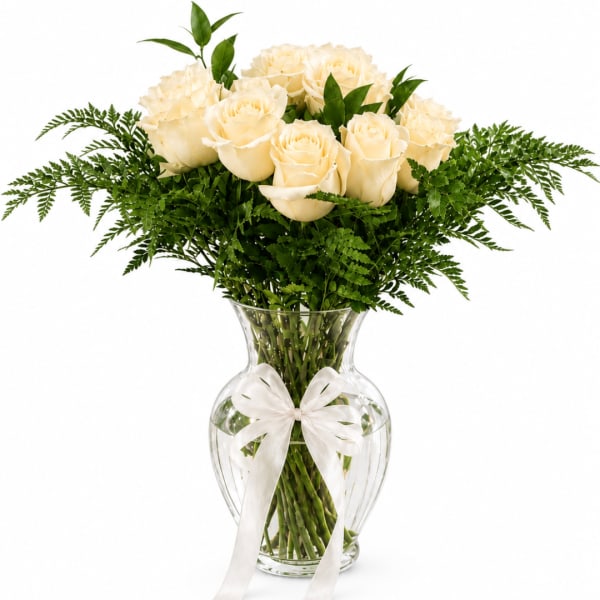 Cream roses arranged in a clear glass vase with a white ribbon