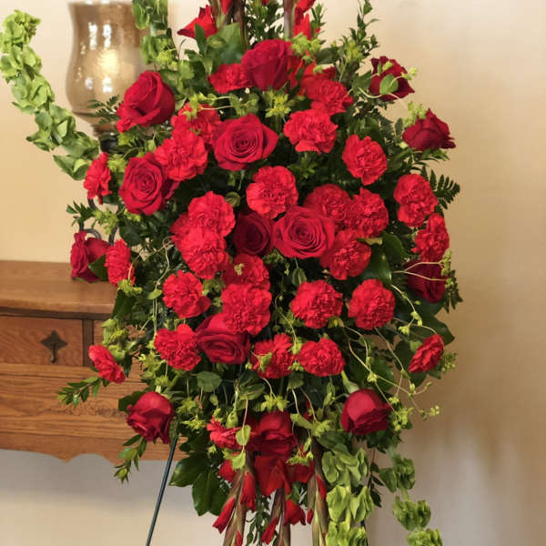 Standing red rose and carnation spray on an easel