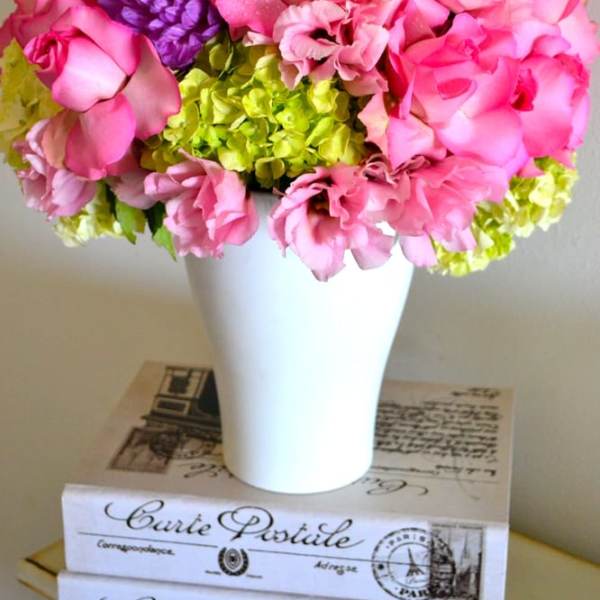 Pink and purple flower arrangement in a white vase
