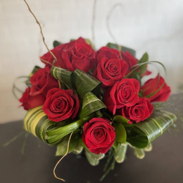 Bouquet of red roses with curled green leaves