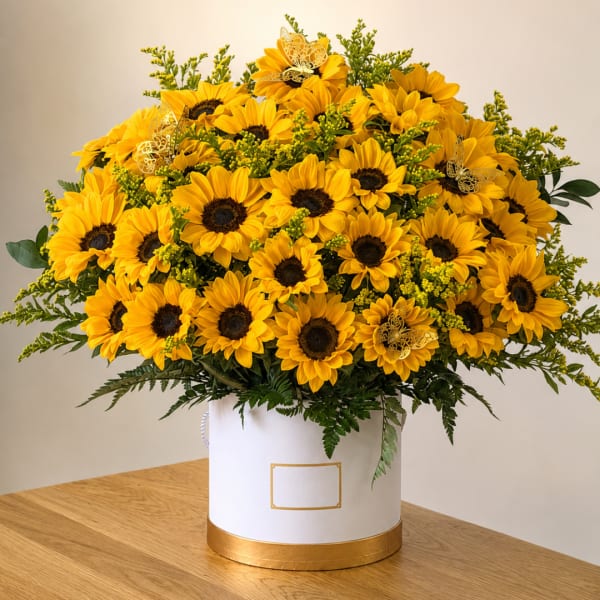 Large bouquet of yellow sunflowers in a white hatbox