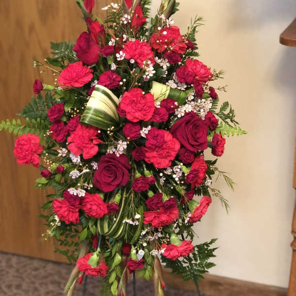 Tall red floral standing spray with roses and carnations