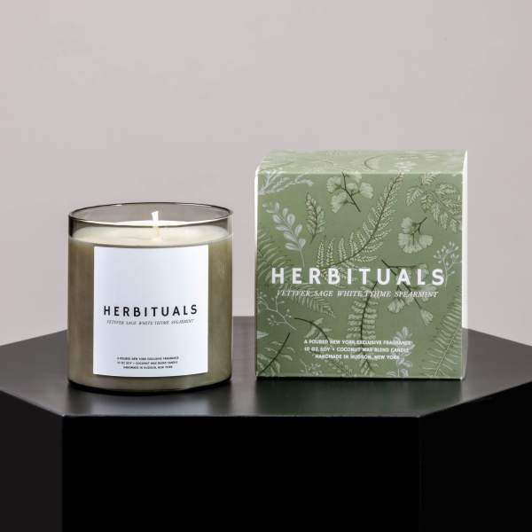 Scented candle in a glass jar beside its green box