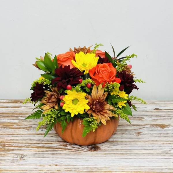 Mixed autumn bouquet arranged in a pumpkin container