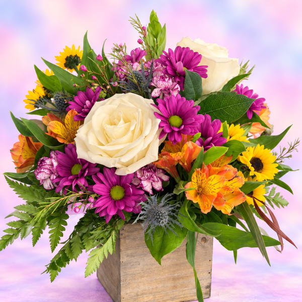 Mixed bouquet with cream roses, purple daisies, and orange alstroemeria in a wooden box