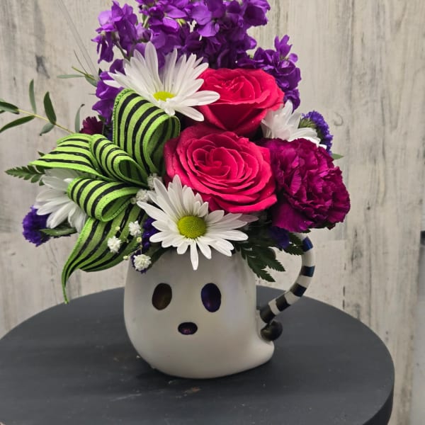 Bright mixed bouquet in a ghost-shaped mug with pink roses, daisies, and purple blooms