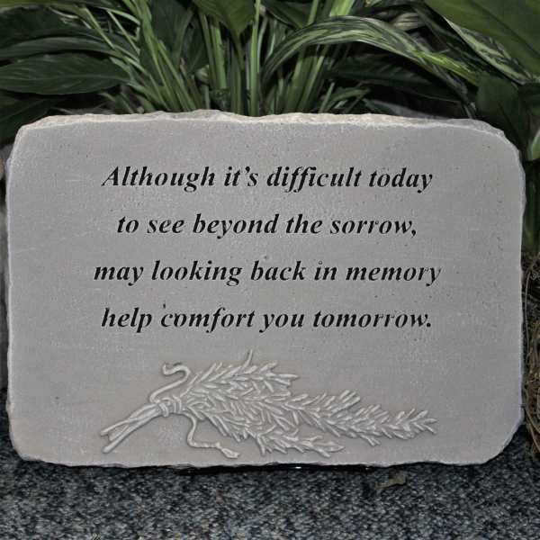 Stone memorial plaque with a sympathy quote and carved floral design