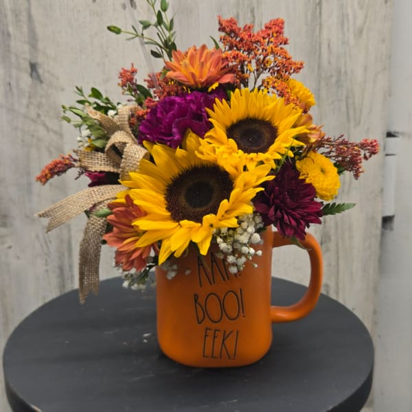 Sunflower bouquet in an orange mug with burlap ribbon