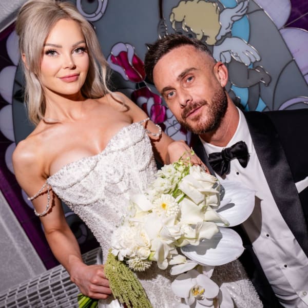 Bride holding a white bouquet beside a man in a tuxedo