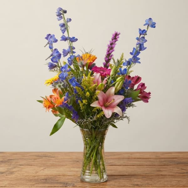 Mixed bouquet of colorful flowers in a clear glass vase
