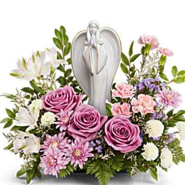 Pink roses and white flowers arranged around a silver angel figurine