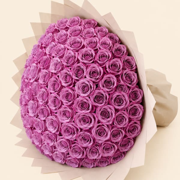 Large bouquet of pink roses wrapped in pale paper