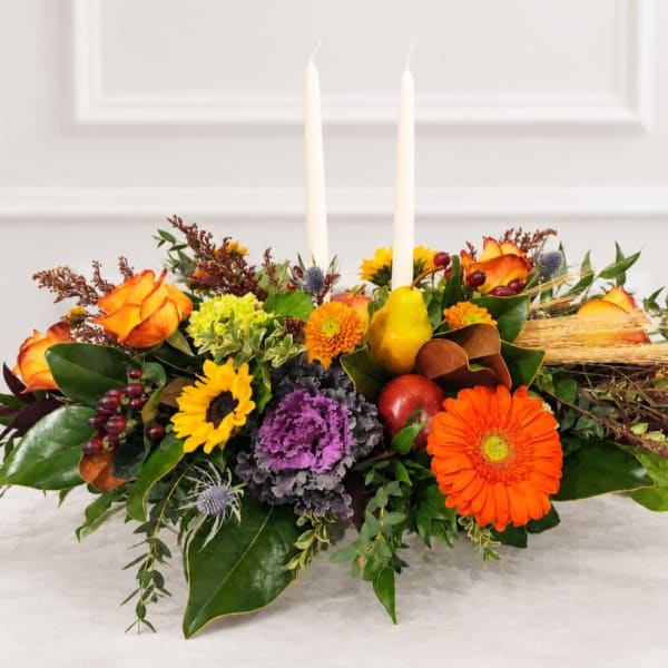 Autumn floral centerpiece with two white taper candles