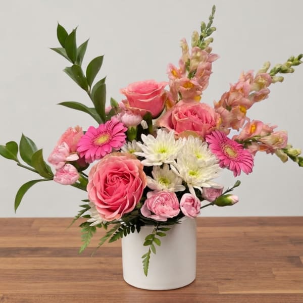 Pink roses and white daisies in a white vase