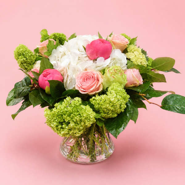 Pink and white flower arrangement in a clear glass vase