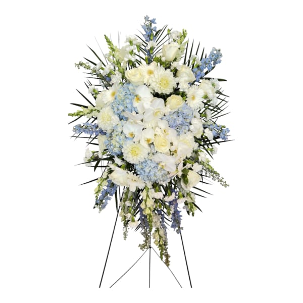 Standing floral spray with white and light blue flowers on a black easel