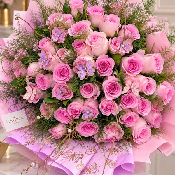 Pink rose bouquet with purple butterfly accents and pink wrapping