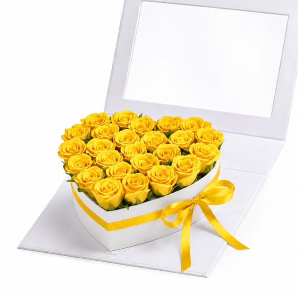 Yellow roses arranged in a heart-shaped white box with a yellow ribbon