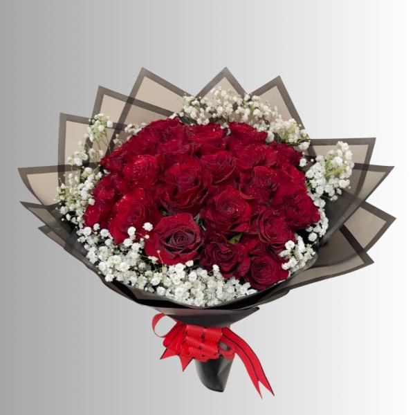 Bouquet of red roses with white baby's breath in black wrap and red ribbon