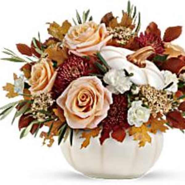 Autumn floral arrangement in a white pumpkin vase with roses and mums