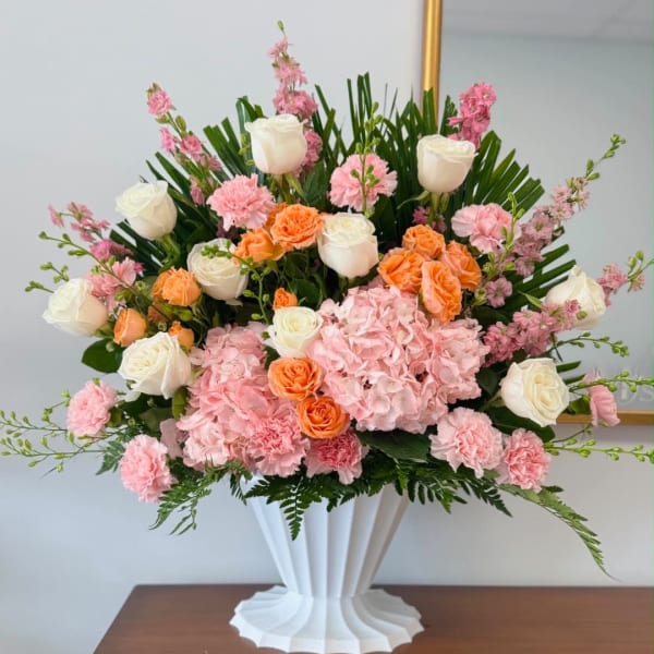 Pink and white floral arrangement in a white vase