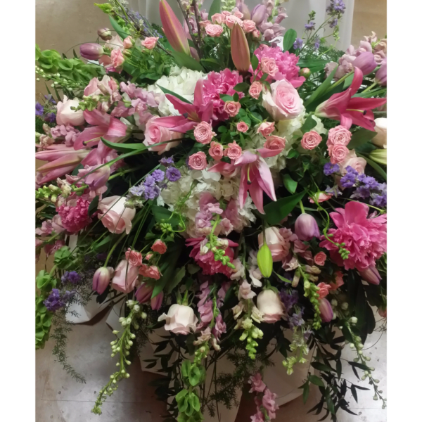 Large pink and white floral arrangement in a white container