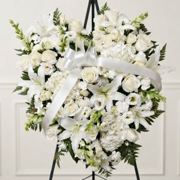 White floral heart wreath with a satin ribbon on a black easel