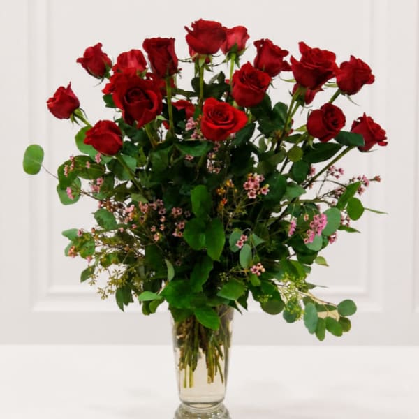 Tall bouquet of red roses in a clear glass vase