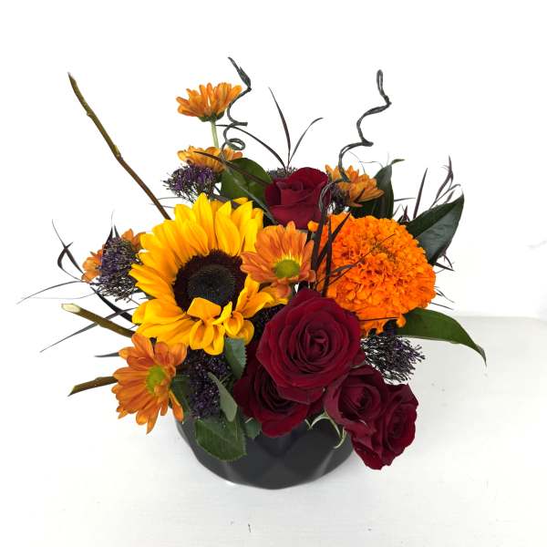 Bouquet of sunflowers, red roses, and orange mums in a black vase