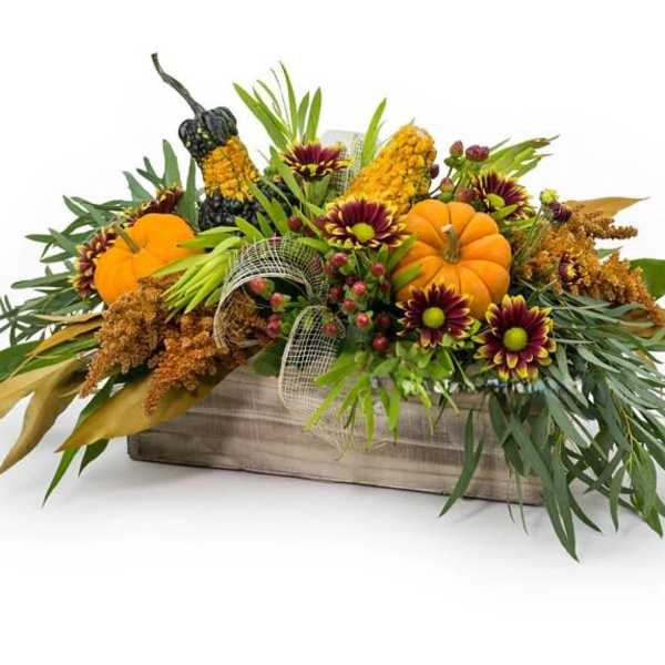Autumn floral arrangement with pumpkins in a wooden box