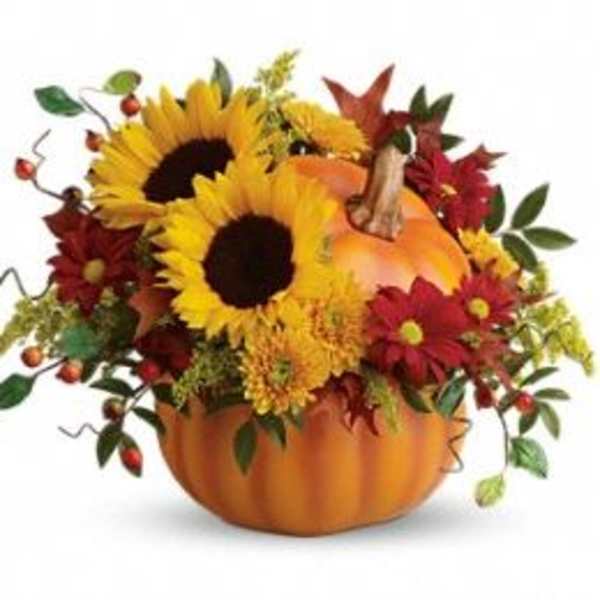 Sunflowers and autumn flowers arranged in a pumpkin container