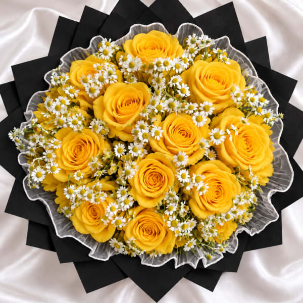 Yellow roses and small white daisies arranged in a round bouquet