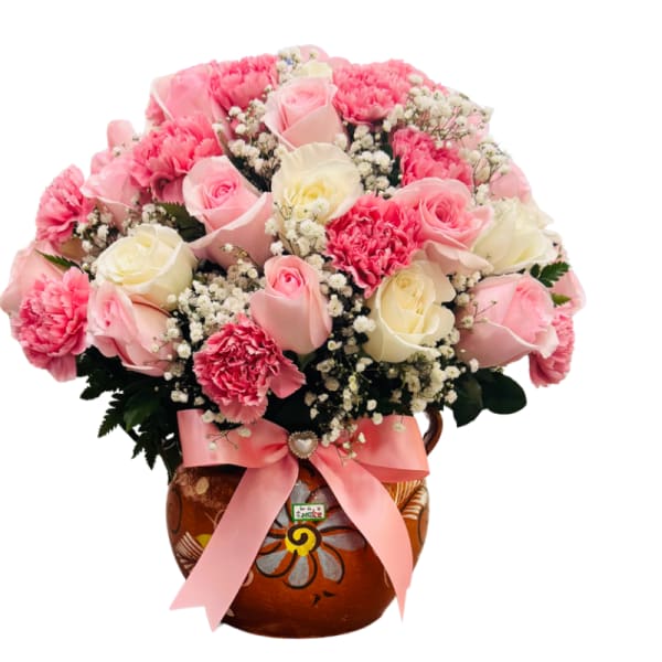 Pink and white rose bouquet in a painted ceramic vase with a pink ribbon