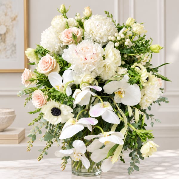 White and blush floral arrangement in a clear glass vase