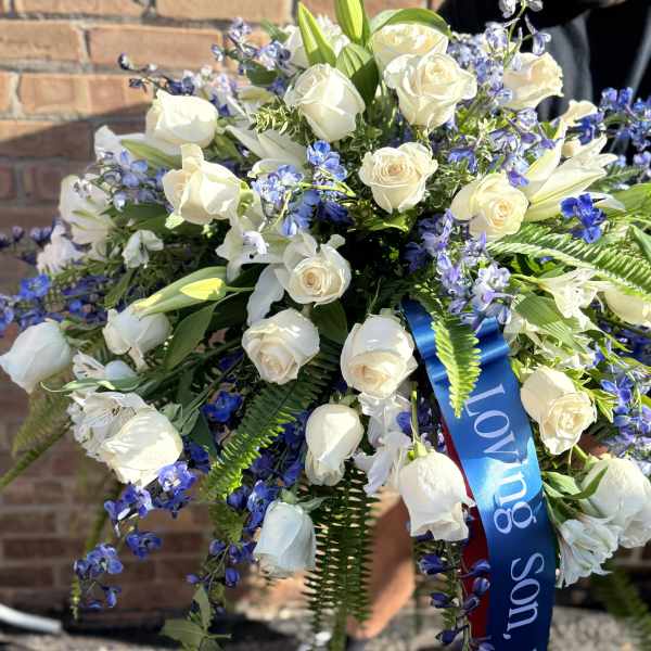 Large bouquet of white roses and blue flowers with a blue ribbon
