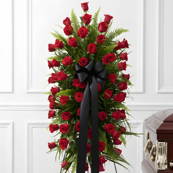 Tall standing spray of red roses with a black ribbon bow