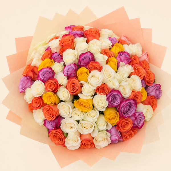 Large bouquet of multicolored roses wrapped in peach paper