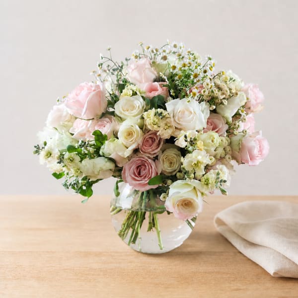 Pink and white roses arranged in a clear glass vase